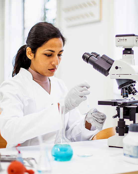 Technician using micrscope