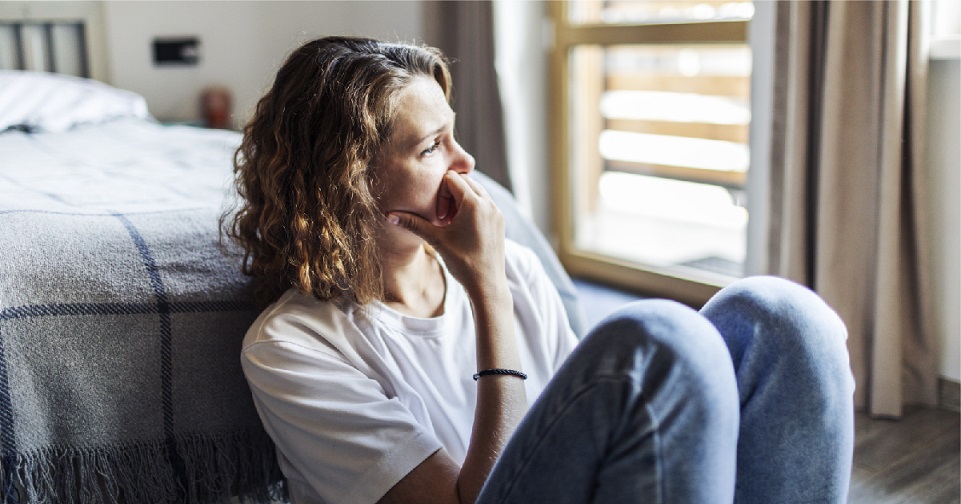 Individual sitting with their hand on the side of their face